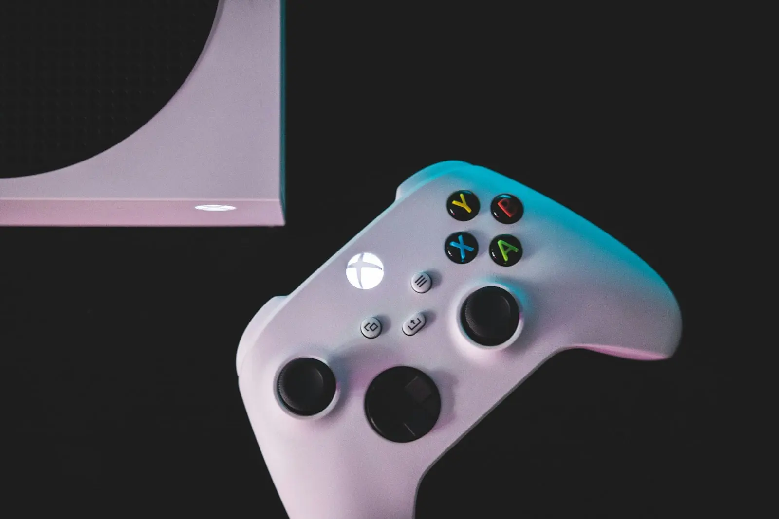 دەسکی یاریی سپیی Xbox لە تەنیشت کۆنسۆڵێکی Xbox Series S